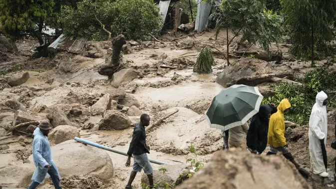 Diterjang Topan Freddy, Lebih dari 100 Orang Tewas di Malawi dan Mozambik Orang-orang menyeberangi sungai yang mengamuk di Blantyre, Malawi, Senin, 13 Maret 2023. Topan Freddy yang tak henti-hentinya yang saat ini menghantam Afrika bagian selatan telah menewaskan sedikitnya 56 orang di Malawi dan Mozambik sejak melanda benua itu untuk kedua kalinya pada Sabtu malam, otoritas di kedua negara telah mengkonfirmasi. (AP Photo/Thoko Chikondi)