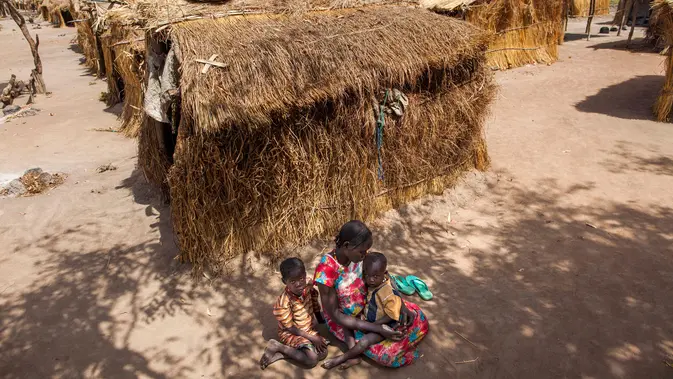 Usai Dilanda Perang, Warga Sudan Menderita Kelaparan dan Krisis Air Bersih Nybol Madut duduk bersama anak-anaknya di tempat penampungan di Sudan Selatan (22/11). Mereka menderita krisis air bersih dan kelaparan karena minimnya persediaan pangan. (AFP Photo/Albert Gonzalez Farran)