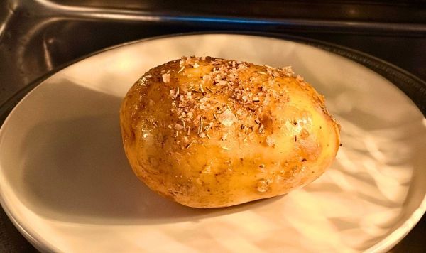 Potato coated in oil and rosemary salt in the microwave