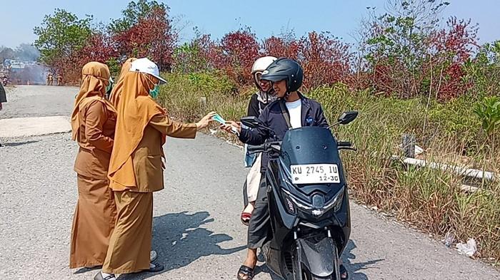 BAGI MASKER - Dinkes Tarakan mulai membagikan masker sebagai pencegahan awal bagi pengendara yang melalui titik karhutla di Kelurahan Pantai Amal, Senin (24/8/2026). TRIBUNKALTARA.COM/ANDI PAUSIAH