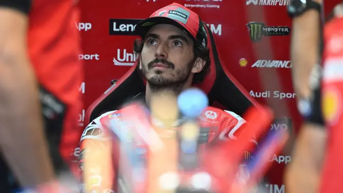 Pembalap MotoGP Italia dari Tim Ducati Lenovo, Francesco Bagnaia, mendengarkan seorang mekanik selama sesi latihan menjelang Grand Prix MotoGP Valencia di sirkuit Ricardo Tormo di Cheste pada 15 November 2025. (Jose Jordan/AFP)
