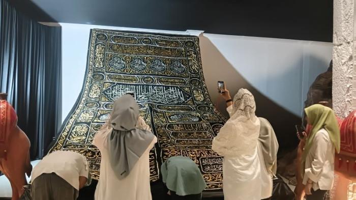 KISWAH - Pengunung melihat dari dekat dan mencium Kiswah Kabah Asli yang didatangkan dari Mekah, Arab Saudi, dalam pameran di The Jungle, Bogor, Jawa Barat, pada Selasa (25/8/2026)