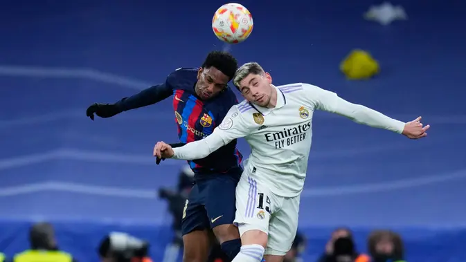 Pemain Barcelona Alejandro Balde (kiri) berduel memperebutkan bola dengan pemain Real Madrid Federico Valverde pada pertandingan sepak bola leg pertama semifinal Copa del Rey di Stadion Santiago Bernabeu, Madrid, Spanyol, 2 Maret 2023. Barcelona sukses megalahkan Real Madrid dengan skor 1-0 berkat gol bunuh diri Eder Militao. (AP Photo/Manu Fernandez)