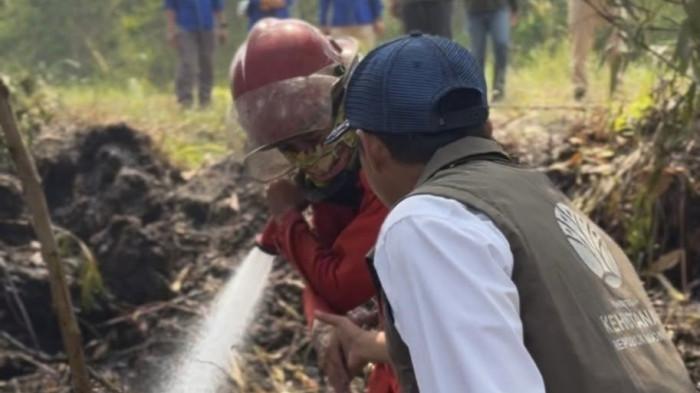 RAJA JULI DI KARHUTLA - Menteri Kehutanan Raja Juli Antoni saat membantu proses water bombing atau penyiraman air dari udara ke lahan gambut yang terbakar di Kalimantan Selatan. Temuan gambut yang masih mengeluarkan asap menjadi perhatian karena bara di bawah permukaan dapat memicu kebakaran kembali.