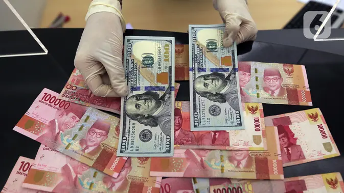 Karyawan menunjukkan uang dolar AS dan rupiah di Jakarta. (Liputan6.com/Johan Tallo)