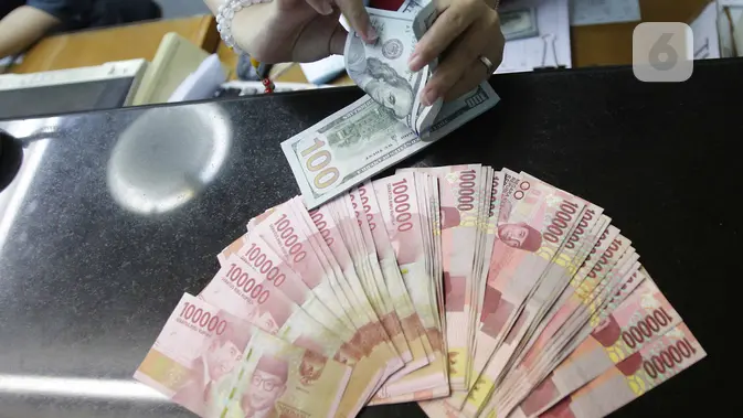 Teller menukarkan mata uang dolar ke rupiah di Jakarta (Liputan6.com/Angga Yuniar)