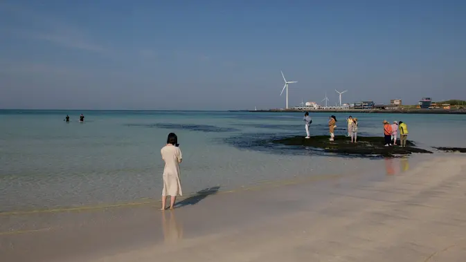Wisata Jeju menawarkan permainan di pantai Woljeongri di pulau Jeju, Korea Selatan (11/5/2019). Topografi Pulau Jeju terbentuk sekitar 2 juta tahun lalu oleh aktivitas vulkanis. Di tengah-tengah pulau muncul Hallasan (Gunung Halla), gunung tertinggi di Korea (1.950 m). (AFP Photo/Ed Jones)