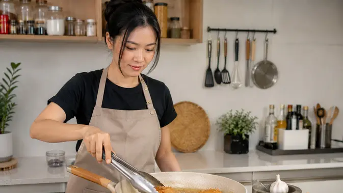 ilustrasi seorang perempuan membuat ayam goreng bawang putih (AI Generated)