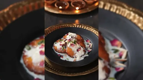 Delicious traditional Indian malpua sweet topped with thick rabdi dry fruits rose petals and silver vark.