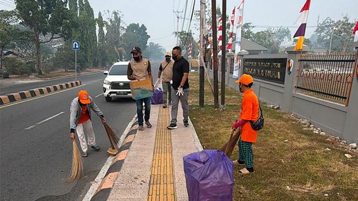 KARHUTLA DI BIAK - Anggota Komisi II DPR Papua, Johanes Markus Wakum, membagikan masker kepada warga Biak yang tengah membersihkan jalanan, Kamis (27/8/2026). Asap pekat melanda  Biak Numfor akibat kebakaran hutan dan lahan (Karhutla). (dk. Pribadi)