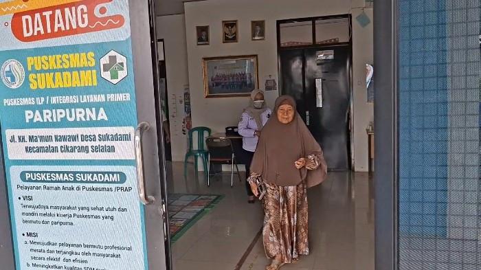 CEK KESEHATAN GRATIS- Seorang warga berjalan keluar usai dilakukan pemeriksaan Cek Kesehatan Gratis (CKG) di Puskesmas Sukadami Kecamatan Cikarang Selatan, Kabupaten Bekasi pada Rabu (26/8/2026). Berdasarkan data Dinas Kesehatan Kabupaten Bekasi, Puskesmas Sukadami capaiannya 10,9 persen dari 356.778 keseluruhan warga yang melakukan CKG tahun 2026 ini. (Muhammad Azzam/ Tribun Bekasi).