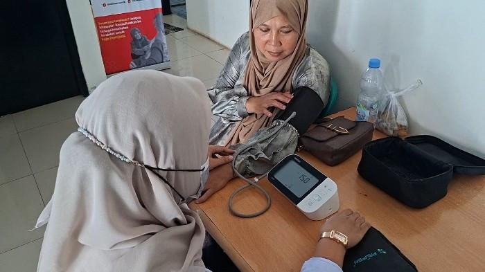 CEK KESEHATAN GRATIS- Magdalina (44) Warga Kampung Cijambe, Desa Sukadami, Kecamatan Cikarang Selatan saat dilalukan pemeriksaan di Puskesmas Sukadami Kecamatan Cikarang Selatan, Kabupaten Bekasi pada Rabu (26/8/2026). Ia alami stroke setengah badan dan penyakitnya terdeteksi usai melakukan cek kesehatan gratis (CKG) program Kementerian Kesehatan. (TribunBekasi.com/Muhammad Azzam)