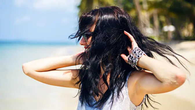 Ilustrasi perempuan sedang beraktivitas di pantai/freepik.com/haritanita Membuat Rambut Lebih Berkilau (Foto dok: Freepik/haritanita).