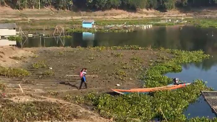 Seorang pria menggendong bocah untuk berangkat sekolah di tepian waduk Saguling, Bandung Barat, Jawa Barat, Jumat 28 Agustus 2026 pagi. Sejumlah anak sekolah berangkat sekolah naik rakit menyeberangi Waduk Saguling.