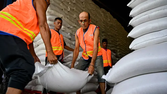 Ketersediaan stok beras ini sebagai bentuk dukungan terhadap penanganan bencana, khususnya di provinsi-provinsi yang rawan terdampak. Tampak dalam foto, para pekerja membongkar karung-karung beras di gudang Badan Urusan Logistik (Bulog) di Lambaro, Provinsi Aceh pada 29 Desember 2025. (CHAIDEER MAHYUDDIN/AFP)