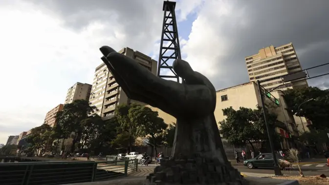 Sebuah patung tangan yang memegang rig pengeboran minyak difoto di luar perusahaan minyak milik negara Petroleos de Venezuela S.A. (PDVSA) di Caracas pada 26 Februari 2025. Presiden AS, Donald Trump, mengumumkan pada 26 Februari 2025 bahwa ia akan membatalkan 