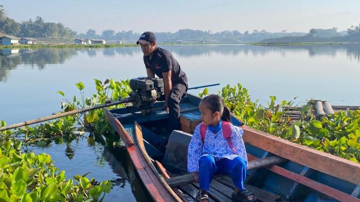NAIK PERAHU - Dudung Febrian, warga Kampung Sadang, Desa Budiharja, Cililin, Bandung Barat, setiap hari mengantar anak bungsunya yang masih TK menyeberangi Waduk Saguling menggunakan perahu mesin.