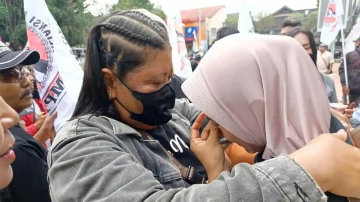 MENANGIS - Anik Sriningsih (berkerudung), Presidium Aliansi Masyarakat Pati Bersatu (AMPB) sekaligus istri dari Supriyono alias Botok, dihibur seorang rekannya ketika menangis di tengah Konferensi Pers yang digelar oleh AMPB di depan Kantor Bupati Pati, Selasa (20/1/2026).