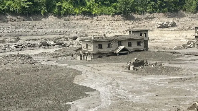 Sebuah rumah tampak terendam sebagian di dalam air berlumpur setelah banjir bandang melanda Trishuli Bazar di distrik Nuwakot, Nepal. (AFP/ Prakash Mathema)