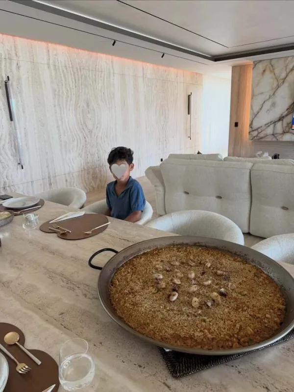 Inside the villa, natural stone is the main material. The living room wall is covered with cream-colored travertine stone with horizontal veins, creating a luxurious look but not too cold.