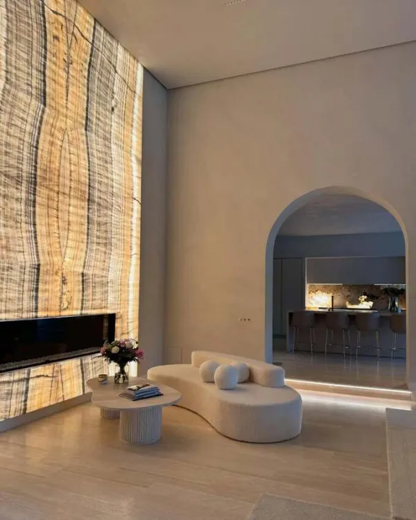 The floor uses large, brightly colored porcelain stone slabs. This material is tiled seamlessly from the living room to the dining room and terrace, helping the spaces connect with each other and creating a larger feeling.