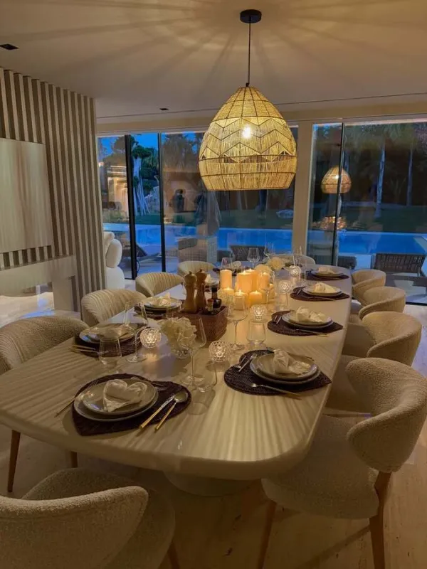 The dining room is where the whole family often gathers. The large rectangular dining table is made from travertine stone, consistent with the wall, while the table corners are rounded to create a softer feeling. Above the table is a lamp made from rattan, creating a handmade highlight for the modern space. During Ronaldo and Georgina's wedding, the large table also became the focal point when the whole family sat together.