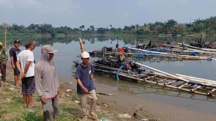 DEMO TAMBANG PASIR - Sejumlah warga Desa Cindaga, Kecamatan Kebasen, Kabupaten Banyumas, saat mendatangi depo pasir yang menggunakan mesin sedot, pada Selasa (18/8/2026). Sebelumnya warga telah memasang patok atau portal yang menghalangi aktifitas lalu lalang truk penambangan pasir menggunakan mesin yang telah berlangsung hampir dua bulan.