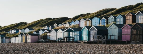 Panoramic view of beach huts during sunset in Milford on Sea, New Forest, UK. Panoramic view of beach huts during sunset in Milford on Sea, New Forest, UK.