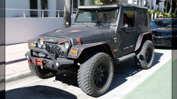 A Jeep Wrangler parked on a city street.