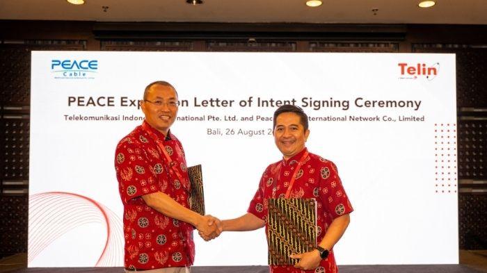 CEO Telin in Singapore Indarto dan CEO PEACE Cable International Network Co., Limited Sun Xiaohua berjabat tangan usai penandatanganan Letter of Intent (LOI) dalam rangkaian BATIC 2026 di Bali.