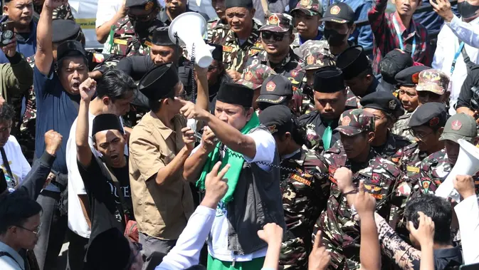 Massa memprotes aturan iddah politik selama setahun yang dinilai hanya disepakati sepihak oleh pimpinan sidang. Hingga sore  situasi di sekitar arena Muktamar masih dijaga ketat oleh pihak keamanan, termasuk Banser dan Pagar Nusa.(Liputan6.com/ Ahmad Apriyono)