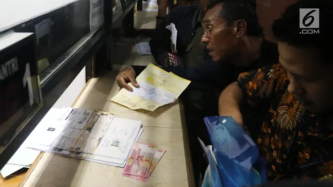 Warga membayar pajak kendaraan di Samsat Polda Metro Jaya, Jakarta, Jumat (16/11). Pemprov DKI menghapuskan sanksi administrasi Pajak Kendaraan Bermotor (PKB) dan sanksi administrasi Bea Balik Nama Kendaraan Bermotor (BBN-KB). (Liputan6.com/Johan Tallo)