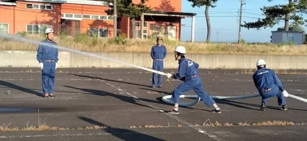 Mr. Huynh Huu Qui (holding a water hose) practiced firefighting skills with members of the Toyama City Volunteer Fire Department, Yamamuro division, in May 2025. Photo: Provided by the character