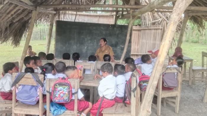 SDN NUNFUTU - Tampak anak-anak sekolah SDN Nunfutu 1 di Kabupaten Malaka mengikuti kegiatan belajar di bawah gedung darurat yang miring dan beratap gewang, Rabu (29/7/2026).