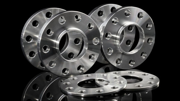 Multiple silver chrome wheel spacers rings on a black background