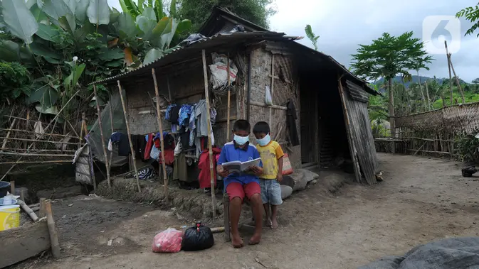 Dua anak membaca buku di depan sebuah rumah di kawasan Sidemen, Karangasem, Bali. (merdeka.com/Arie Basuki)