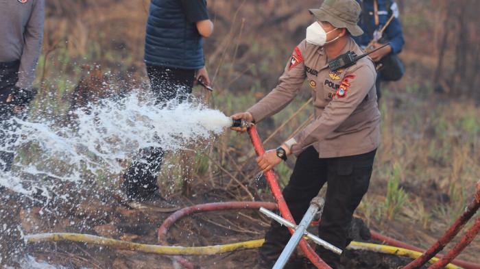 PEMADAMAN KARHUTLA - Polda Kalsel berinovasi menggunakan metode perforasi vertikal dengan sistem suntik ke dalam tanah dari pipa-pipa yang sudah dilubangi di kawasan Guntung Damar Desa Tegal Arum Kelurahan Syamsudin Noor Banjarbaru, Rabu (2/82026). Diharapkan cairan surfaktan yang suntikkan sampai ke dalam tanah mampu  membuat proses pemadaman efektif dan efesian.