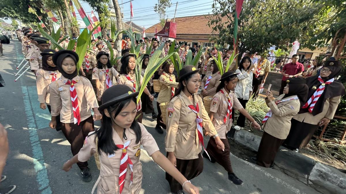 PRAMUKA KLATEN - Peserta Estafet Tunas Kelapa Kwarcab Klaten membawa Tunas Kelapa saat melintasi jalan di Kabupaten Klaten, Rabu (2/9/2026).