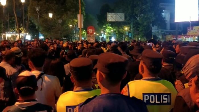 NEGOSIASI - Massa dari Aliansi Masyarakat Sipil bernegosiasi dengan warga soal kapan aksi diakhiri, di Simpang Gramedia, Jalan Jenderal Sudirman, Yogyakarta, Selasa (1/9/2026) malam. Dua kubu berada di sisi utara dan timur dengan ditengahi barikade polisi.