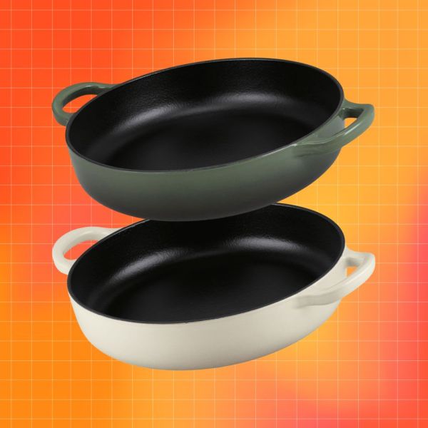 Two oval roasting pans with handles displayed stacked in green and offwhite colors on an orange gradient background Credit: Aldi. Getty Images. EatingWell design.
