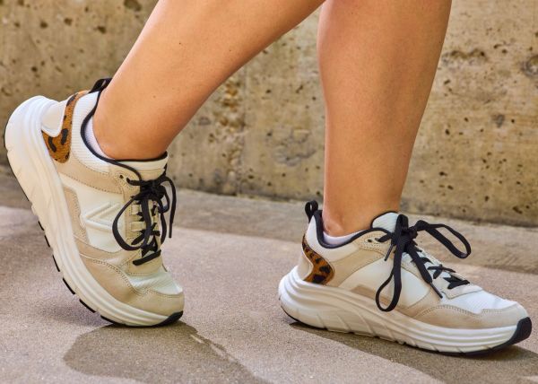 Pair of athletic sneakers with a decorative pattern being worn on a persons feet Credit: EatingWell/Nick Simpson