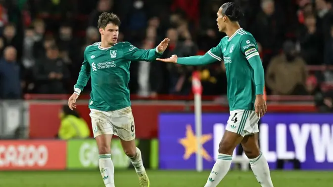 Liverpool Bek Liverpool asal Hungaria #06, Milos Kerkez (kiri), merayakan gol bersama bek Liverpool asal Belanda #04, Virgil van Dijk (kanan), setelah mencetak gol pertama mereka untuk kemenangan 2-1 dalam pertandingan Premier League Inggris antara Brentford dan Liverpool di Stadion Komunitas Gtech, London, Minggu (26-10-2025) dini hari WIB. (Glyn KIRK/AFP)