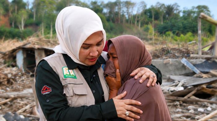 MERANGKUL WARGA - Ketua TP PKK Aceh, Marlina Muzakir Manaf, merangkul warga saat mengunjungi Kampung Sekumur, Kecamatan Sekerak, Aceh Tamiang, Kamis (18/12/2025). Kak Na datang membawa bantuan sekaligus mendengarkan langsung kisah warga yang kehilangan rumah akibat banjir bandang.