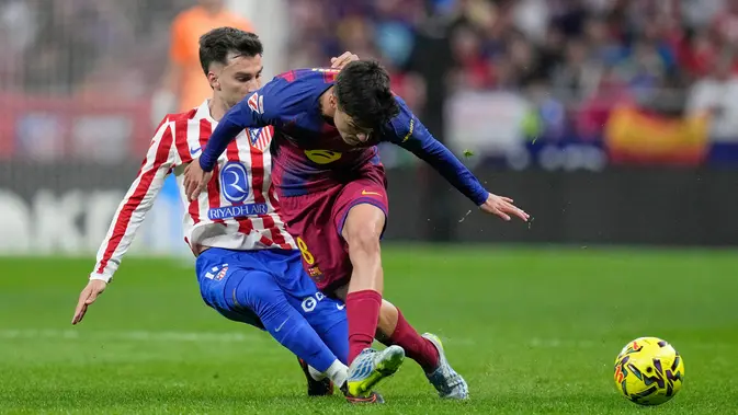 Pemain Barcelona, Pedri (kanan), berebut bola dengan pemain Atletico Madrid, Alex Baena dalam pertandingan Liga Spanyol di Madrid, Spanyol, Minggu (5/4/2026) dini hari WIB. (AP Photo/Bernat Armangue)