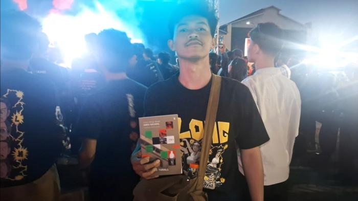 PROJEK-D - Fauzan Nur Hidayat (25) penonton PROJECT-D Vol 5, menunjukkan buku yang ia dapat dari Band Lips!! salah satu penampil di event musik tersebut, di Kawasan De Tjolomadoe, Jl. Adi Sucipto No.1, Paulan Wetan, Malangjiwan, Kec. Colomadu, Kabupaten Karanganyar, Jawa Tengah, Sabtu (5/9/2026).