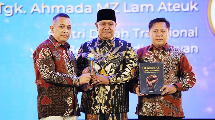 SERAHKAN PIALA – Pemred Serambi Indonesia Zainal Arifin M Nur didampingi Pemimpin Perusahaan Firdaus Darwis menyerahkan piala penghargaan Serambi Awards 2026 kepada Tgk Ahmada Lam Ateuk, pada Malam Apresiasi “Gebrakan Sang Pemimpin” yang digelar di Gedung AAC Dayan Dawood, Universitas Syiah Kuala (USK) di Darussalam, Banda Aceh, Sabtu (29/8/2026) malam.