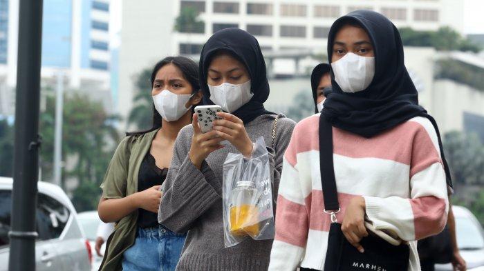Warga beraktivitas menggunakan masker di kawasan Bundaran HI, Jakarta 
