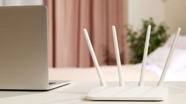 Wi-Fi router on desk next to laptop.