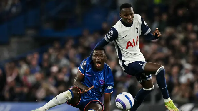 Momen striker Tottenham Hotspur, Pape Sarr dianggap melanggar gelandang Chelsea, Moises Caicedo, sebelum mencetak gol yang akhirnya dianulir oleh wasit dalam laga pekan ke-30 Premier League di Stamford Bridge, Jumat (4/4/2025) dini hari WIB. (Glyn KIRK / AFP)
