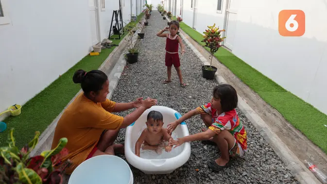 Seorang ibu memandikan anaknya di lingkungan Hunian Sementara (Huntara) di Jalan Kramat Raya, Jakarta, Selasa (8/9/2026). Warga mulai menempati hunian tersebut sejak akhir Juni 2026 setelah sebelumnya tinggal di sekitar bantaran rel kawasan Senen. (KLY/Budy Santoso)